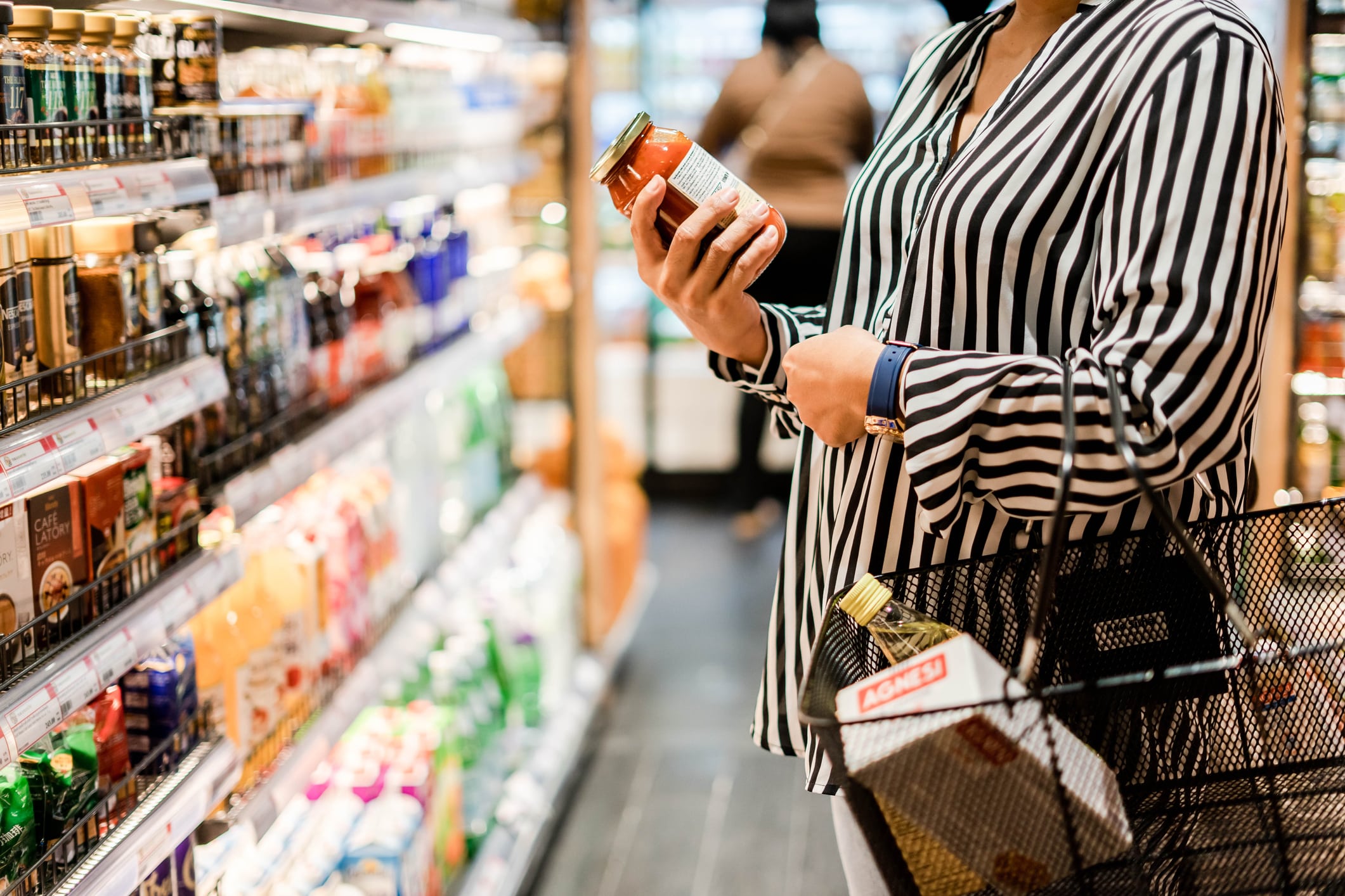 woman is shopping and examining the food product label